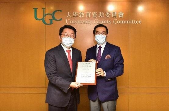 The Chairman of the University Grants Committee (UGC), Mr Carlson Tong (right), presents the 2020 UGC Teaching Award for Early Career Faculty Members to Mr David Seungwoo Lee.